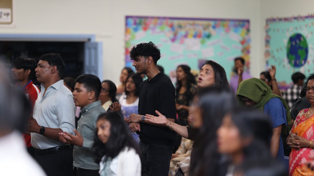Congregation standing in worship with open hands
