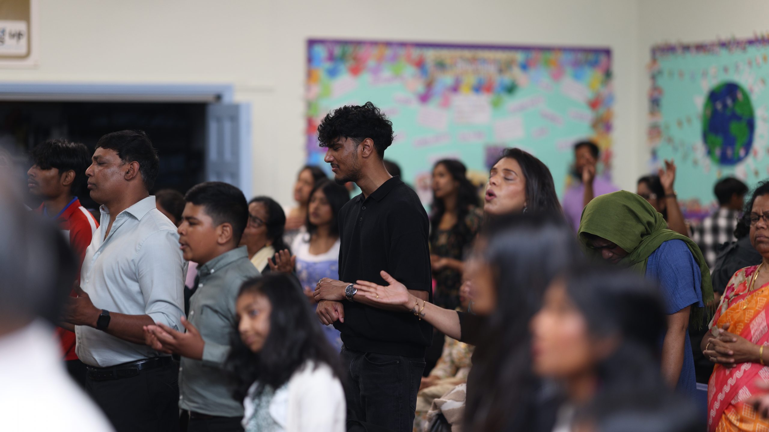 Congregation standing in worship with open hands