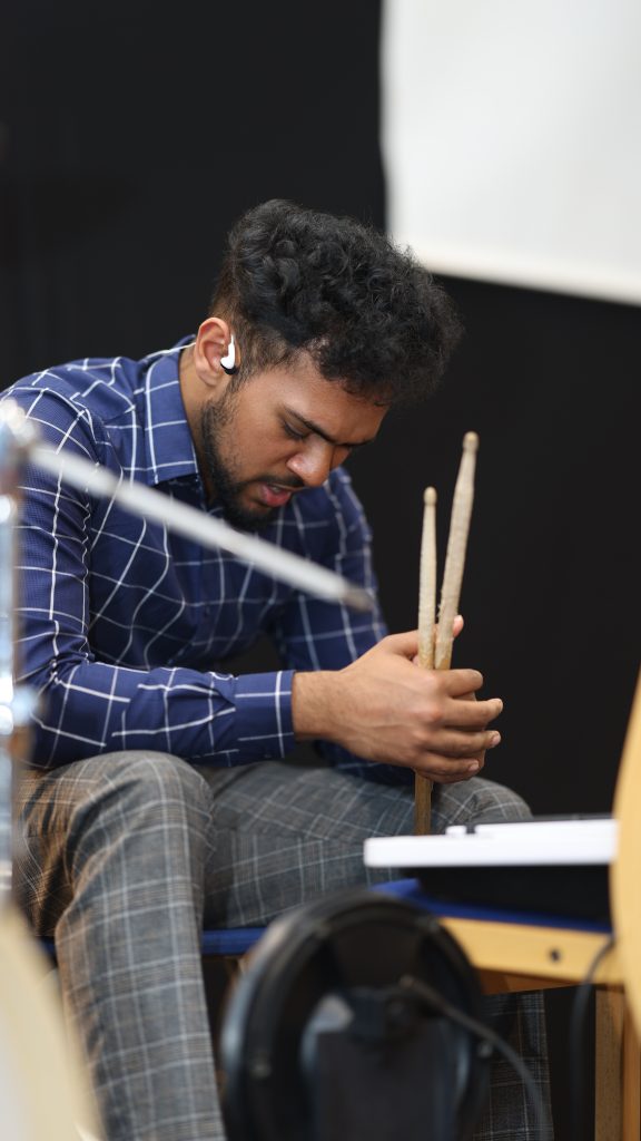 Drummer holding his sticks with his head bowed