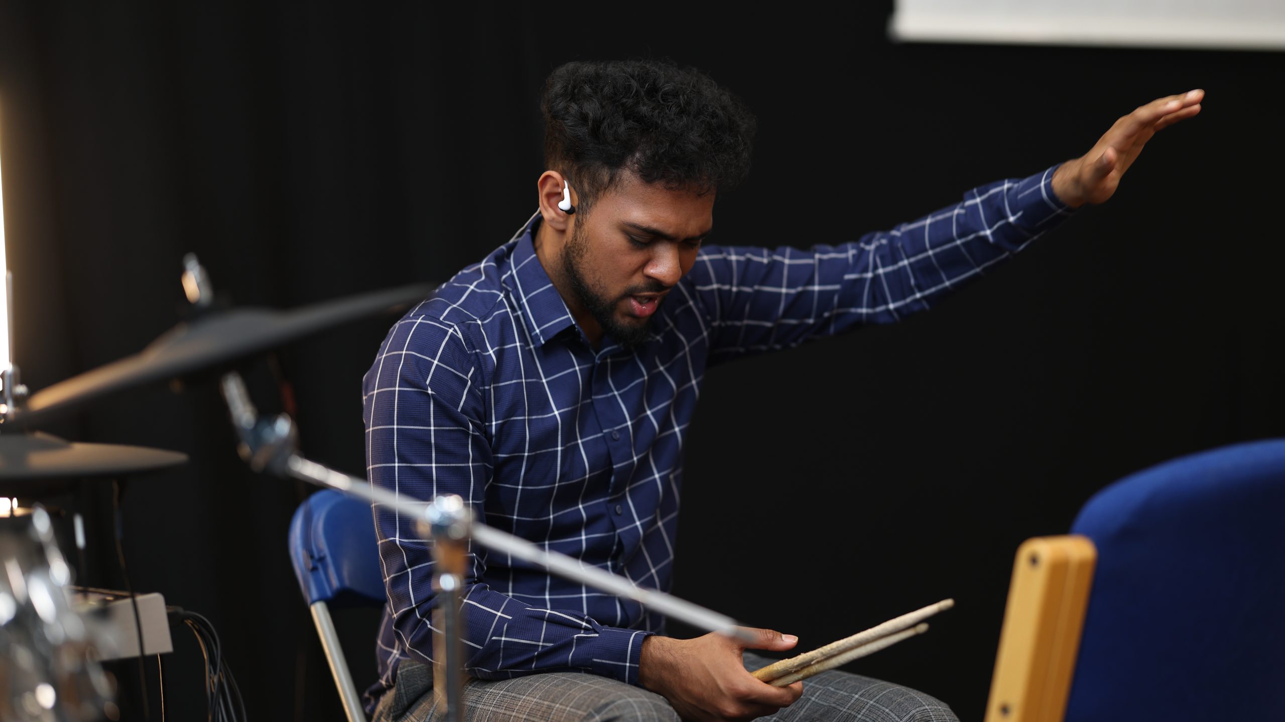Drummer lifting his hand in worship