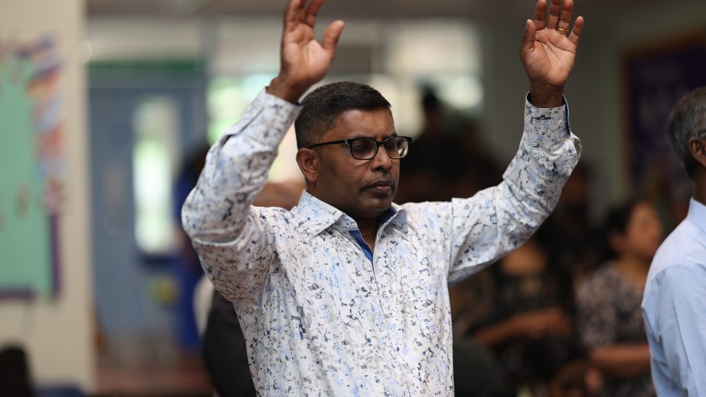 A man worshipping with both hands raised