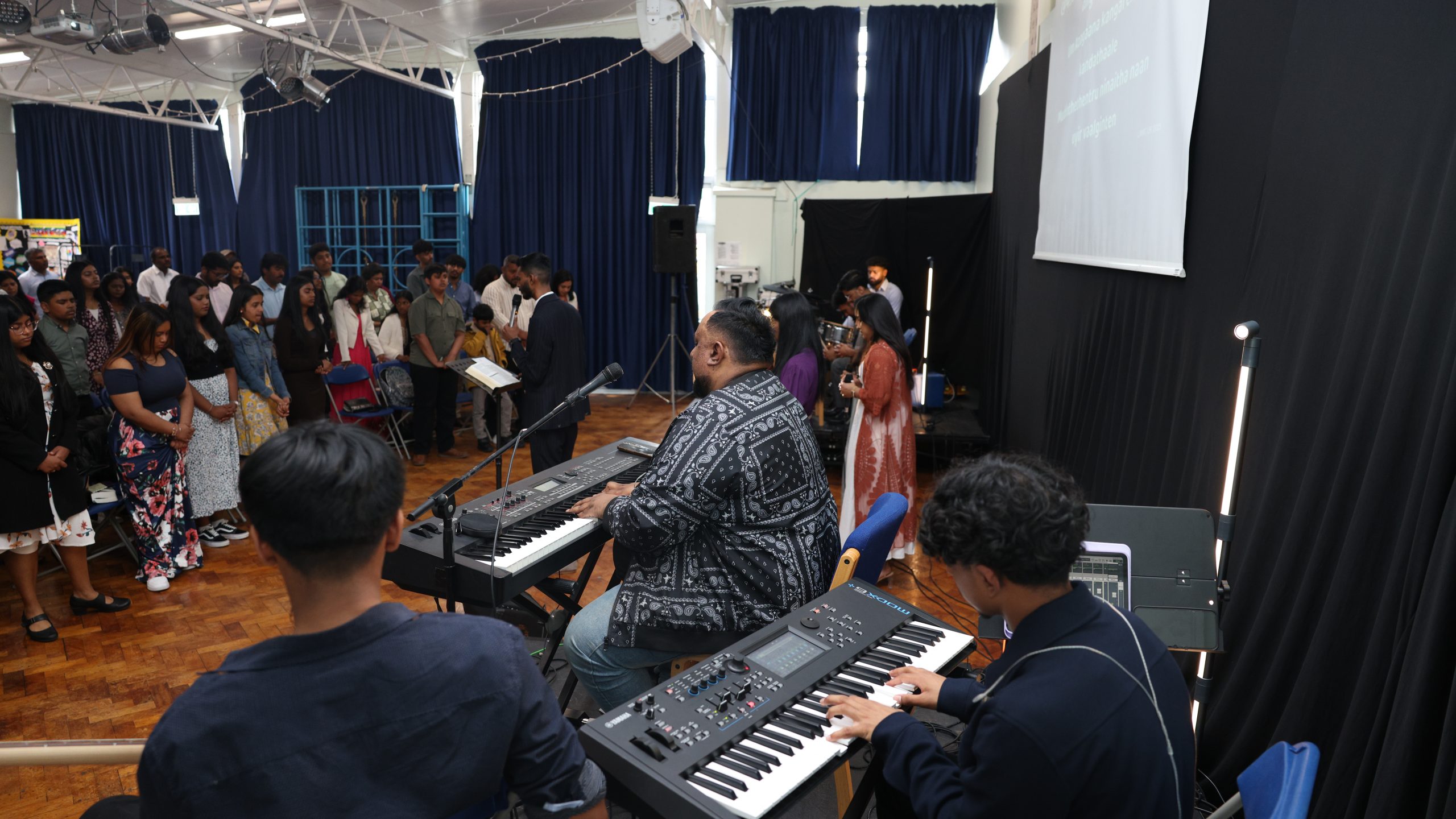 Musicians at the keyboards leading the hall in worship